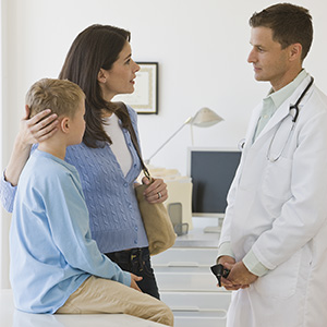 Male doctor talking to mother and son.